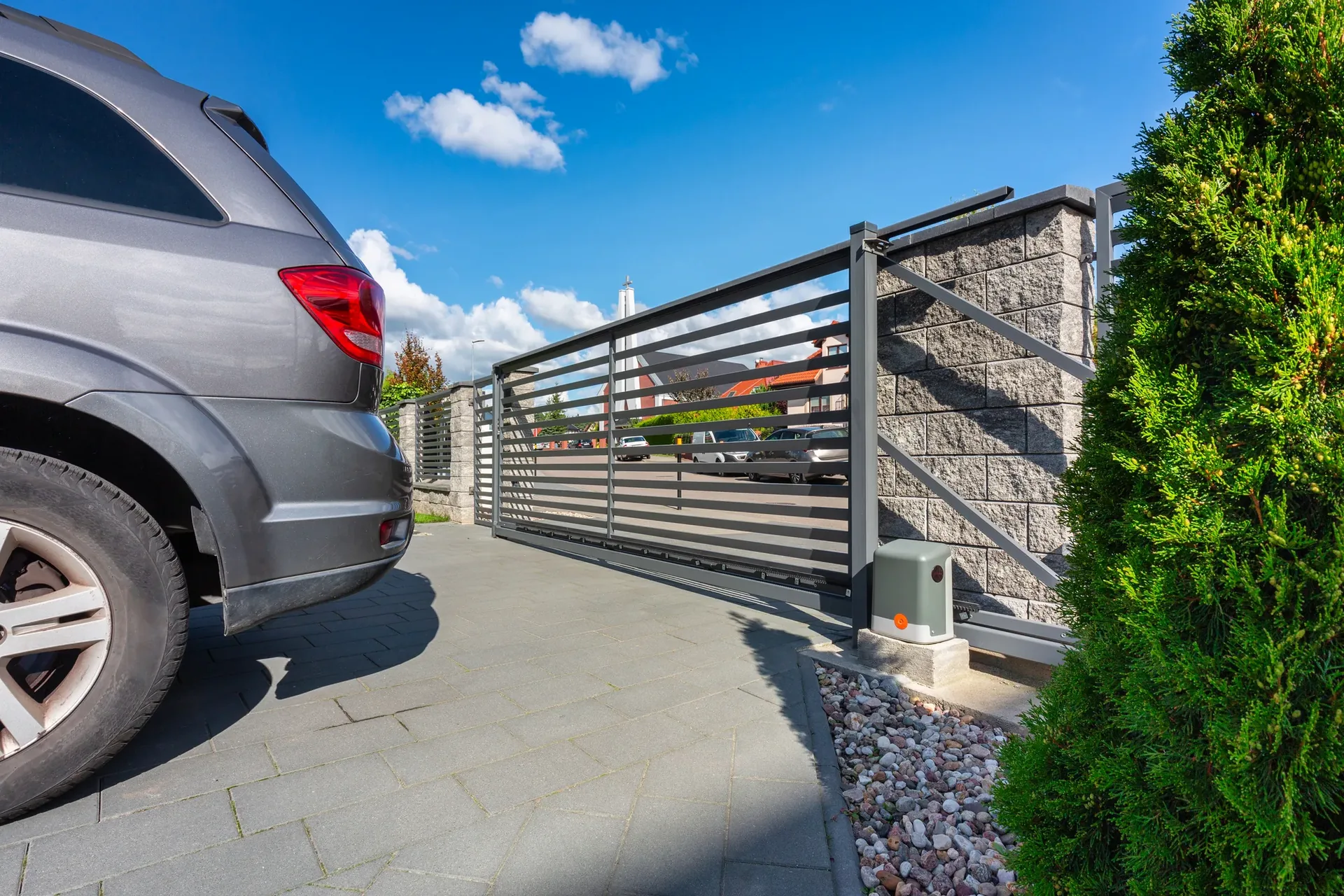 Car driving through an open electric sliding gate